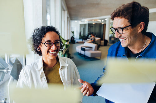 Two professionals share a smile during office discussion