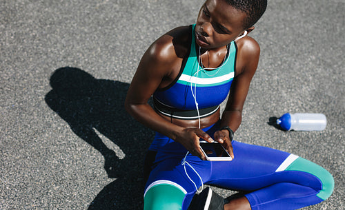 Fit woman on road taking a break after outdoor workout