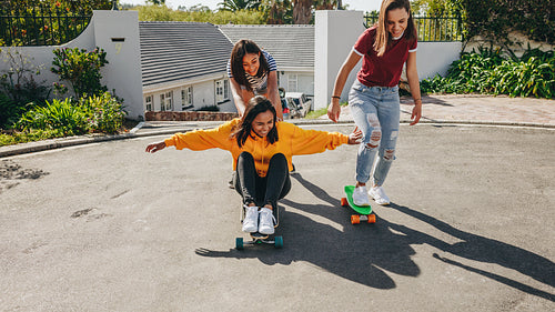 Girls skating in the street on a sunny day