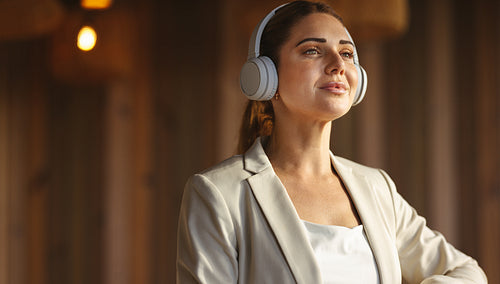 Business woman wearing headphones in a coworking office