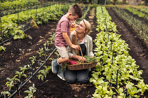 Mother smiling at her son while harvesting on an organic farm