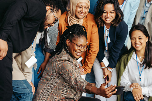 Multiethnic team posing for a photo with smiles and camaraderie in a dynamic workplace setting