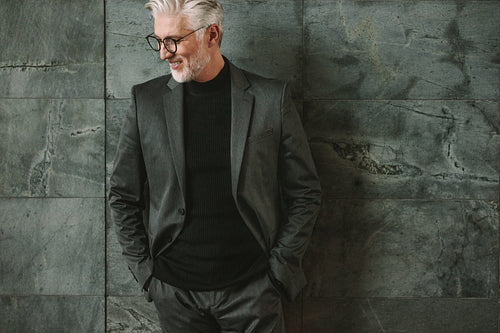 Handsome mature businessman against a wall