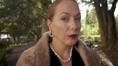 Classy senior woman standing in the park