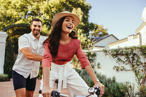 Young man pushing his girlfriend on a bike