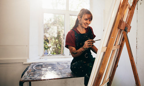 Young painter working in her studio