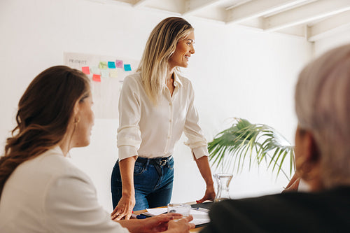 Cheerful businesswoman having a meeting with her team