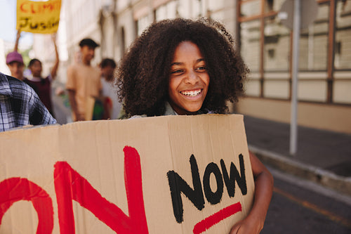 Happy young girl marching against climate change in the city