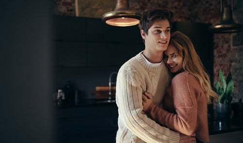 Man hugging his girlfriend at home