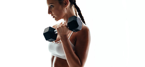 Muscular female exercising with weights