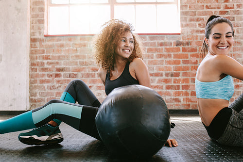 Female friends taking a break from workout in gym