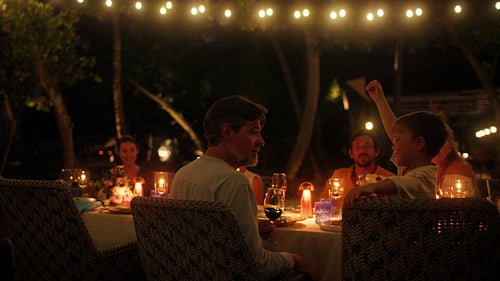 Family enjoying a beautiful evening dinner together at an outdoor island resort