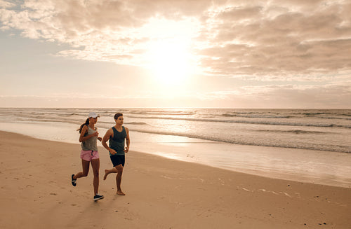 Couple running together on the sea shore