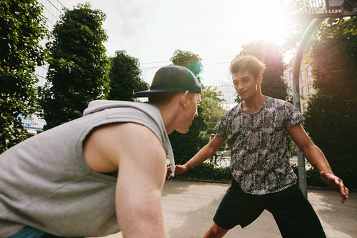 Two teenage friends playing basketball