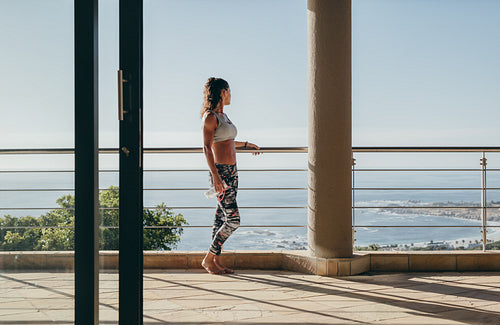 Woman standing in the balcony and looking at the view