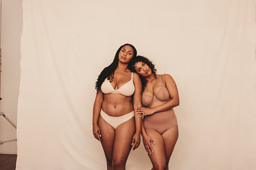 Two body positive young women standing in underwear
