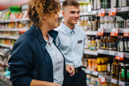 Woman with new employee in supermarket