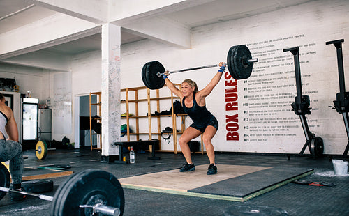 Female performing deadlift exercise with barbell