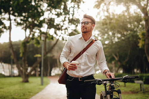 Man enjoying coffee and music while walking to office
