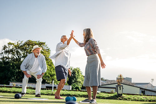 Senior people playing a game of boules in a park