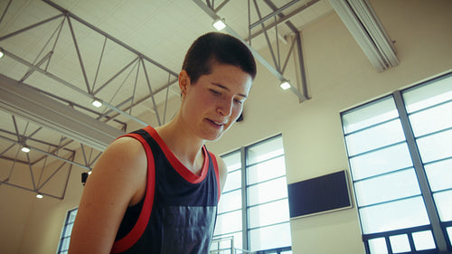 Woman shoots basketball in gym