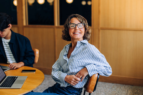 Smiling woman seated at a table in a coworking space