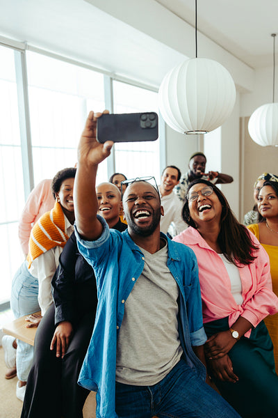 Group of enthusiastic professionals capturing a joyful selfie while sharing smiles