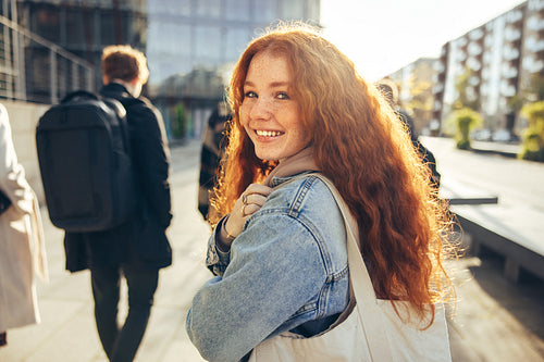 Beautiful student walking and smiling back at camera