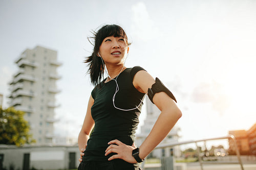 Asian female taking a break during morning run