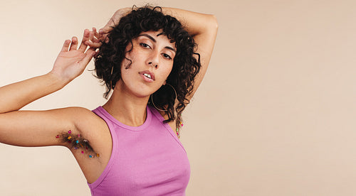 Body confident young woman showing her unshaven arm pits