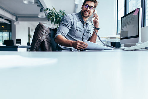 Businessman talking on landline phone