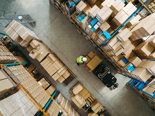 Aerial view of a logistics worker placing goods onto a forklift