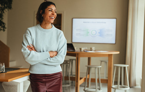 Smiling businesswoman stands confidently in modern office