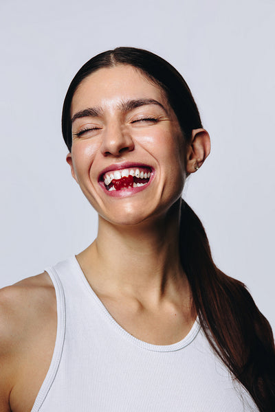 Woman in her 20s laughing with gummy in studio