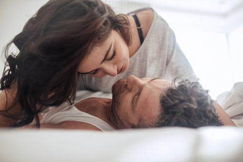 Young couple caressing lying in bed 