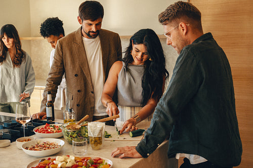 Group of friends preparing a meal together in a cozy modern kitchen
