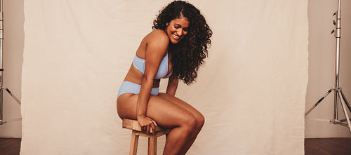 Self-confident young woman smiling while wearing blue underwear