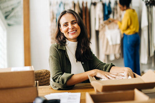 Woman fulfilling orders for her ecommerce site in a clothing boutique