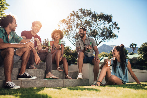 Friends hanging out with beers in backyard garden