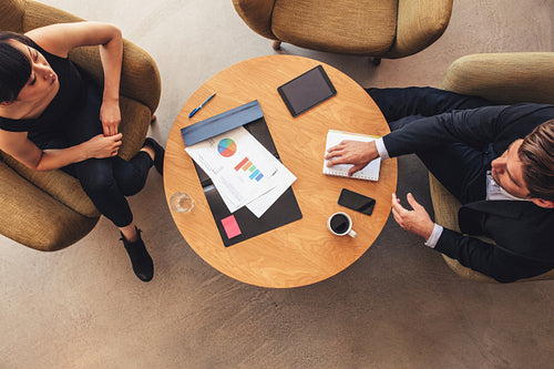 Young businessman and woman meeting in office lobby