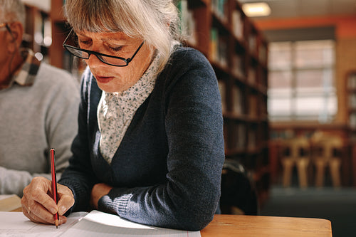 Close up of a senior woman writing in her book