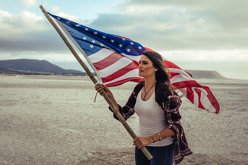 Attractive woman with American Flag on beach