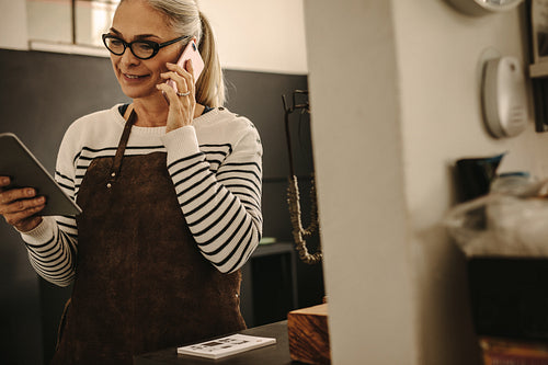 Goldsmith with digital tablet making a phone call