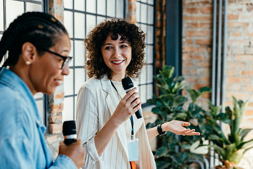 Women empowering each other during a work presentation in a modern office setting