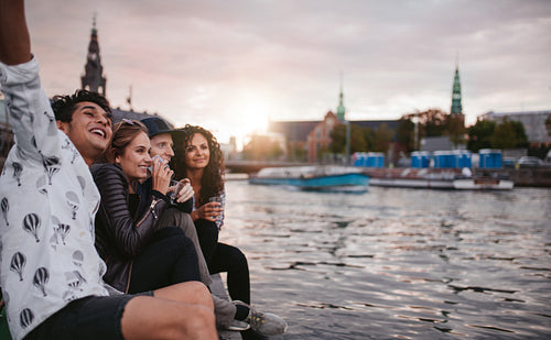 Friends having a good time by the canal in city