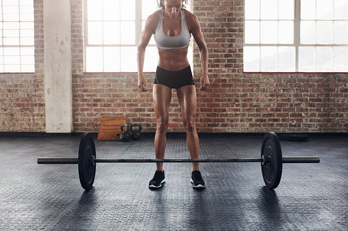 Muscular young woman exercising with heavy weights
