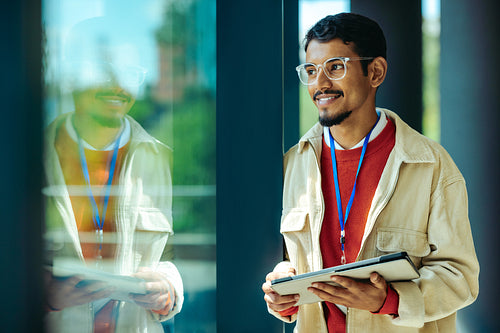 Thoughtful professional with tablet reflecting on ideas