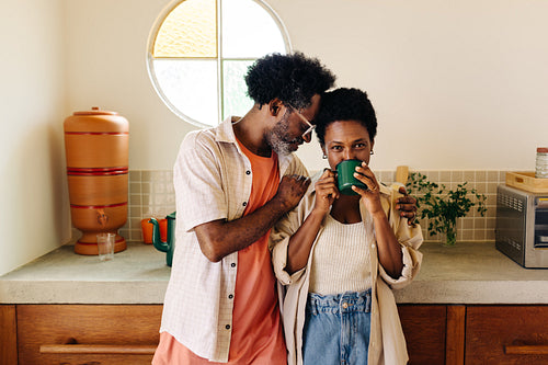 Affectionate couple enjoying a warm cup of coffee in a cozy kitchen
