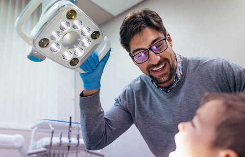 Dentist inspecting oral cavity of little boy