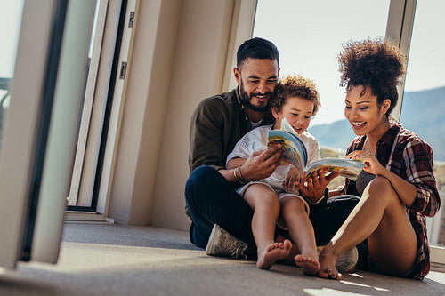 Couple sitting with their child reading a story book